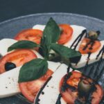 photo en gros plan de tranches de tofu et de tomates décoré avec du vinaigre balsamic