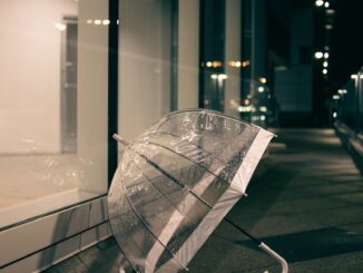 un parapluie transparent posé sur le côté d'un bâtiment